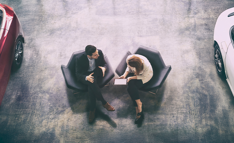 Overhead shot of two people discussing security in a dealership